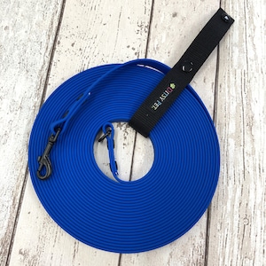 May include: A coiled, vibrant blue dog training lead with a black swivel clip and a black handle. The handle has a press stud closure and the text "DITSY PET." in green, pink, and yellow. The lead is made of a durable, waterproof material.