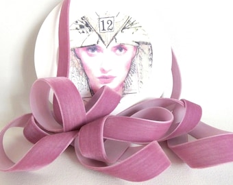 May include: A spool of dusty rose velvet ribbon, approximately 1 inch wide, with a vintage-style illustration of a woman's face on a white background. The text "Silk Cottage Ribbon" is printed in black at the top of the image.
