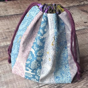 May include: A white ceramic mug with a black handle and the text "But First, Coffee" in a black, handwritten-style font. The mug is on a white surface.