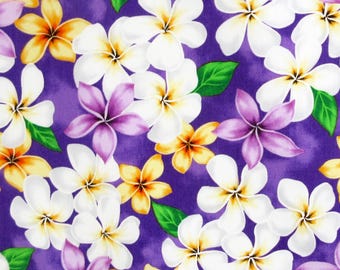 May include: Purple fabric with a floral pattern featuring white, yellow, and purple flowers. The flowers are arranged in a random pattern and are all in bloom.