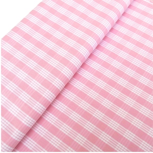 May include: A folded piece of pink and white striped fabric. The fabric has a repeating pattern of pink and white stripes running diagonally across the image. The fabric appears to be cotton or a similar material.