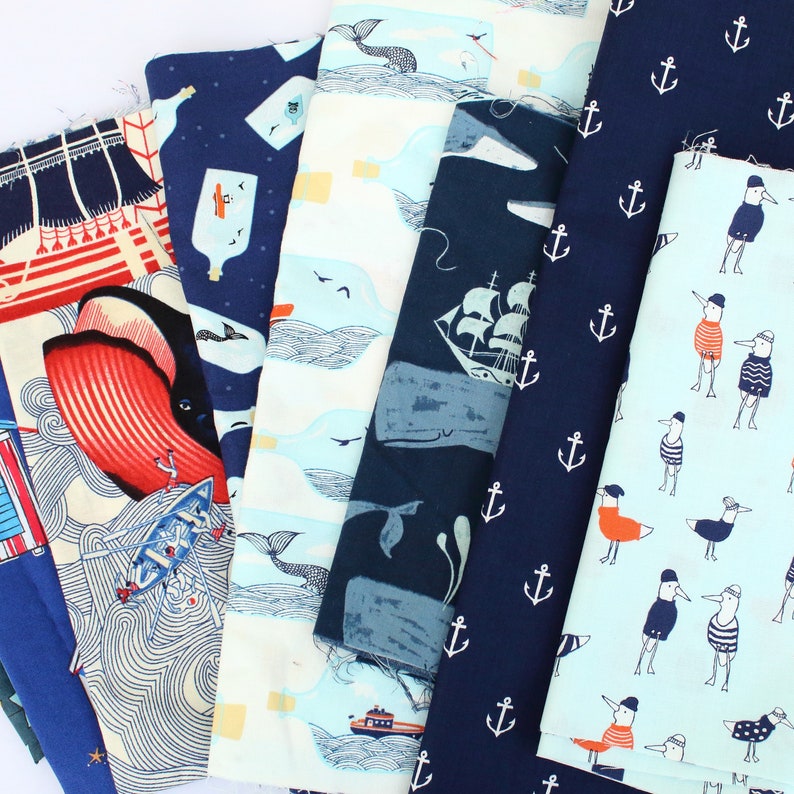 May include: A collection of 10 fabric panels featuring a variety of nautical themes. The panels are in shades of blue, white, and red, and feature illustrations of anchors, whales, boats, and other nautical imagery.