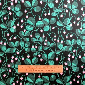 May include: Black fabric with a repeating pattern of green leaves and pink strawberries. The leaves have a striped design. The text "BLUE PACIFIC FABRICS" is printed on a wooden ruler.
