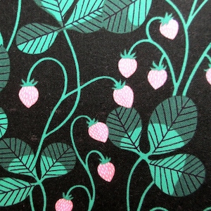 May include: Close-up of a fabric with a repeating pattern of pink strawberries, green leaves, and vines on a black background. The leaves have a detailed, layered design. The strawberries are a soft pink.