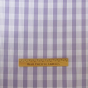 May include: A close-up of a fabric with a plaid pattern in shades of lavender and white. A wooden ruler with the text "BLUE PACIFIC FABRICS" is at the bottom of the image.