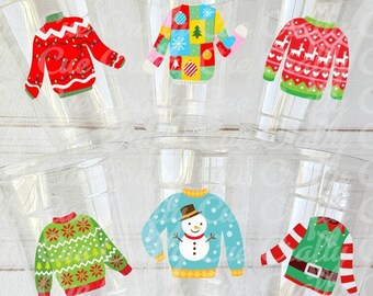 May include: Clear plastic cups with various Christmas sweater designs. The sweaters are red, green, blue, and multi-colored, featuring patterns like reindeer, snowflakes, and a snowman. The cups are arranged in a layered display.