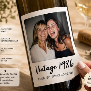 May include: A rectangular adhesive wine bottle label featuring a color photograph of two smiling people. The label includes the text Vintage 1986 and AGED TO PERFECTION in black font. Additional text icons indicate waterproof vinyl, durable, scratch resistant, and fade resistant ink.