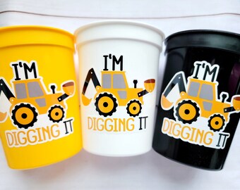May include: Three yellow, white, and black plastic cups with a construction vehicle graphic and the text "I'm digging it".