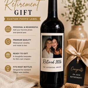 May include: A dark glass wine bottle with a custom rectangular label featuring a photograph of two people, the text Retired 2026, and the phrase THE ADVENTURE BEGINS. The label also lists features including custom photo, special year, and 750ml size.