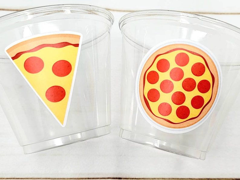 Peut inclure: Deux gobelets en plastique transparent avec des autocollants sur le th&egrave;me de la pizza. Un gobelet a une part de pizza avec du pepperoni, l'autre a une pizza enti&egrave;re avec du pepperoni.