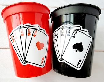 Könnte beinhalten: Zwei Plastikbecher mit einem Royal Flush-Design. Der rote Becher hat einen Royal Flush von Herzen und der schwarze Becher einen Royal Flush von Pik.