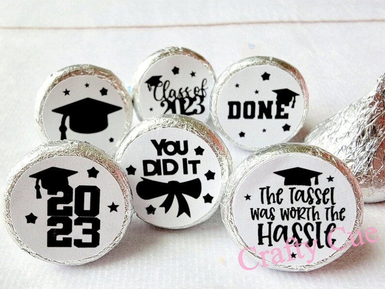 May include: A set of 6 graduation themed favor stickers for Hershey's Kisses. The stickers feature black and white designs with text that says "Class of 2023", "You Did It", "Done", "The Tassel Was Worth The Hassle", and "2023" with a graduation cap.