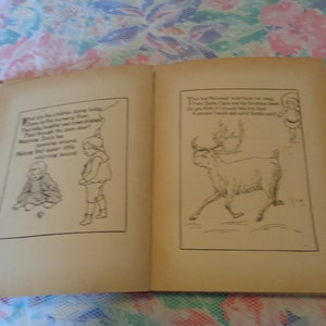 May include: An open vintage book with red binding, featuring black and white illustrations and text. One page shows a reindeer, the other depicts children. The illustrations are in a classic storybook style.