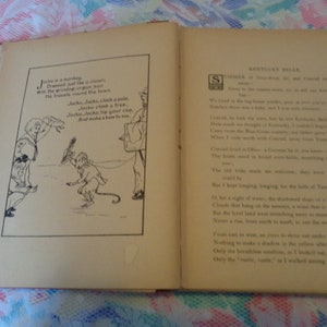 May include: An open vintage book with red binding, displaying two pages. The left page features a black and white illustration of a monkey and a boy, with accompanying text. The right page contains printed text titled "Kentucky Belle".