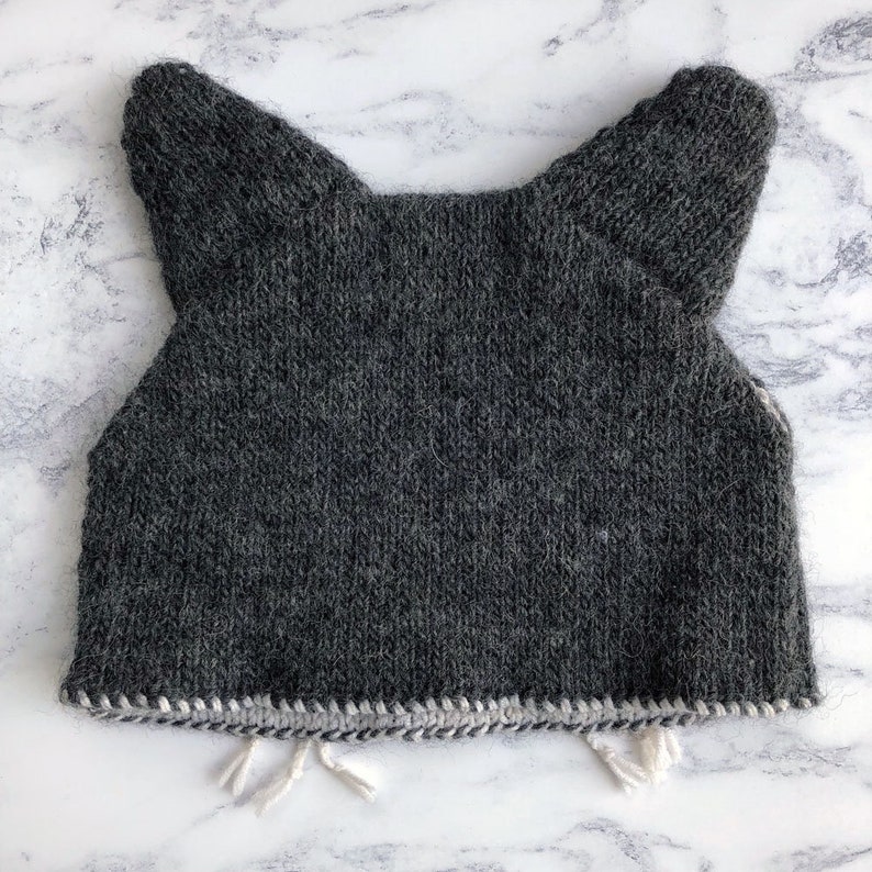 the back of a cat head knitted tea cosy in grey