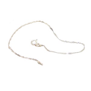 May include: A silver chain necklace with a lobster clasp.