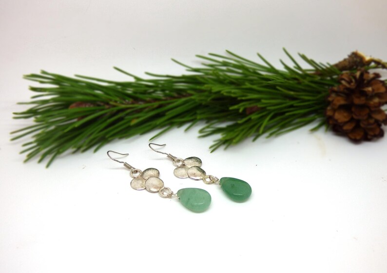 Peut inclure: Une paire de boucles d'oreilles en argent avec un groupe de petits cercles en argent et une pierre verte en forme de larme suspendue &agrave; chaque boucle.
