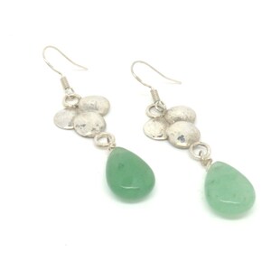 Peut inclure: Boucles d'oreilles pendantes en argent avec un groupe de petits disques en argent martel&eacute;s et une pierre verte en forme de larme.