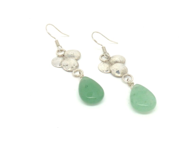Peut inclure: Boucles d'oreilles pendantes en argent avec un groupe de petits disques en argent martel&eacute;s et une pierre verte en forme de larme.