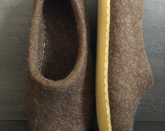 May include: A pair of brown felt slippers with a tan leather sole. The slippers are soft and cozy, perfect for keeping your feet warm in the winter.