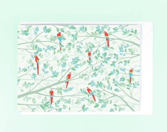 May include: A white card with a green and white leafy pattern and red, blue, and yellow parrots perched on the branches.
