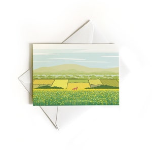 May include: A green field with yellow flowers and a red fox in the distance. The field is surrounded by green trees and a blue sky with white clouds. In the background, there are mountains.