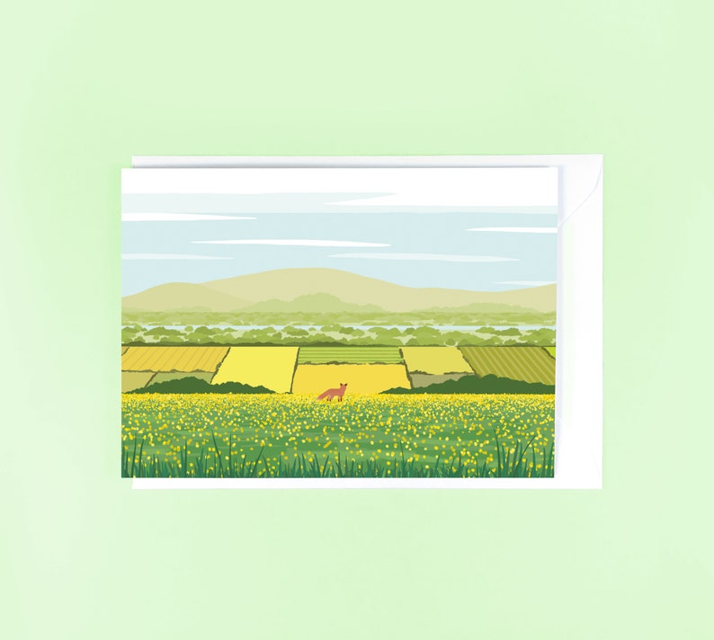 May include: A digital illustration of a green field with yellow flowers and a small orange fox in the distance. The background shows a green hill and a blue sky with white clouds.