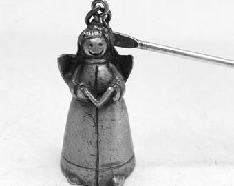 Apagavelas de peltre antiguo con ángel de coro y niña sonriente