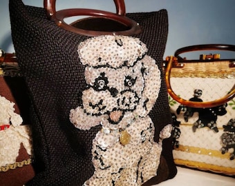 Könnte beinhalten: Eine schwarze Handtasche mit einem Poodle-Design aus Pailletten. Die Tasche hat einen Holzgriff und einen braunen Boden. Der Pudel besteht aus silbernen Pailletten mit schwarzen Akzenten. Ein goldfarbener Anhänger hängt am Hals des Pudels.