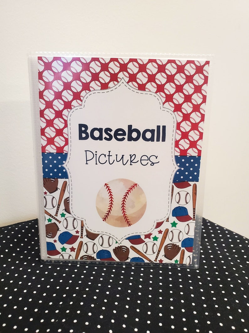Peut inclure: Un classeur en plastique transparent avec un motif sur le th&egrave;me du baseball rouge, blanc et bleu. La couverture avant pr&eacute;sente un ballon de baseball avec des coutures, des battes, des gants et des casquettes. Le titre "Baseball Pictures" est imprim&eacute; en noir sur fond blanc.