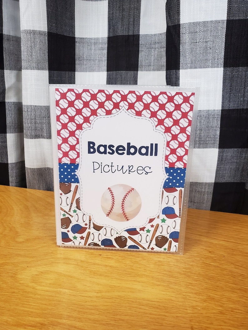 Peut inclure: Un album photo en plastique transparent avec une couverture &agrave; th&egrave;me baseball rouge, blanc et bleu. La couverture pr&eacute;sente un ballon de baseball, des battes, des gants et des &eacute;toiles. Le texte sur la couverture indique "Baseball Pictures".