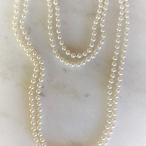 May include: A double strand of white pearl beads necklace.