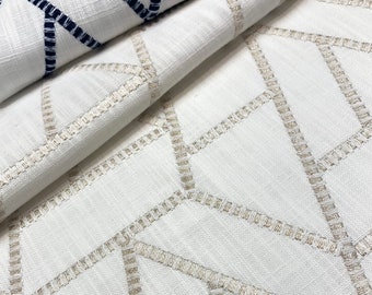 May include: White fabric with a geometric pattern of beige stitching. The fabric is folded in half, showing the stitching on both sides.