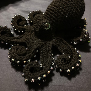 May include: Black crocheted octopus with iridescent beads around the tentacles.