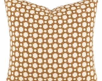 May include: A square throw pillow featuring a repeating geometric pattern of white four-pointed star shapes set against a solid tan background. The fabric has a textured appearance with clean edges and a plump, filled shape that maintains a consistent form.
