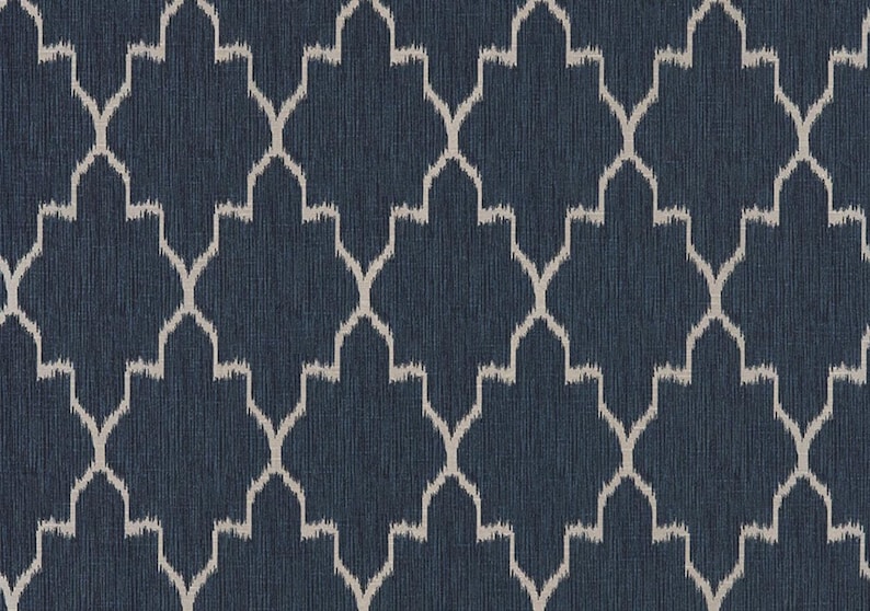May include: A dark navy blue fabric featuring a repeating geometric pattern of light beige, ikat-style interlocking ogee shapes. The material has a subtle, fine vertical texture throughout, creating a consistent and structured visual appearance.