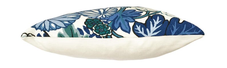 May include: A white pillow with a blue and green floral pattern. The pillow is made of a soft, comfortable fabric and has a white backing.