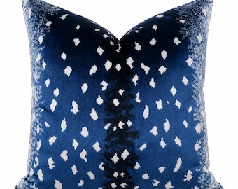 Può includere: Un cuscino quadrato in velluto blu navy profondo con un motivo a macchie bianche. Il design presenta una fascia verticale centrale di segni blu scuro e bianchi, con il motivo a macchie che sfuma verso i bordi esterni del cuscino.