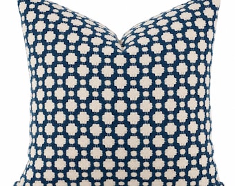 May include: A square throw pillow featuring a deep navy blue background with a repeating off-white geometric pattern. The design consists of small, interconnected cross-like shapes and dots, creating a textured, woven appearance across the entire surface.