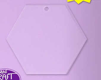 May include: A clear, frosted hexagon-shaped acrylic blank ornament with a hole at the top for hanging.  The ornament is on a light purple background.  Multiple sizes available.