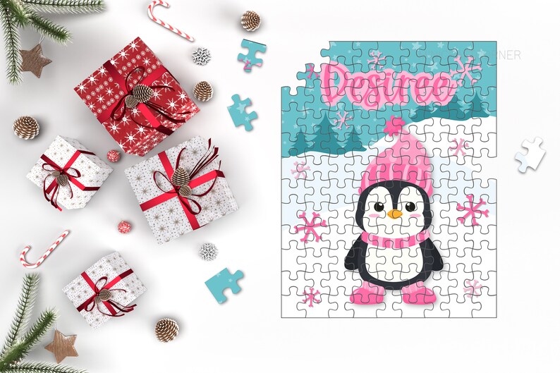 May include: A personalised jigsaw puzzle with a cartoon penguin in a pink hat and scarf, with the name "Desiree". The puzzle is surrounded by Christmas gifts, pine cones, and candy canes.