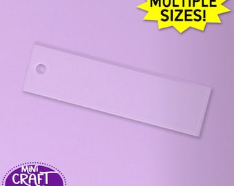May include: A clear plastic bookmark with a hole at the top. The bookmark is on a light purple background. The text "MULTIPLE SIZES!" is in a yellow starburst shape at the top of the image.