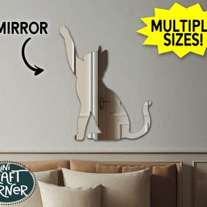 May include: A cat-shaped mirror with a reflective surface, shown on a wall. The word "MIRROR" is above the cat, with an arrow pointing to it. A yellow starburst graphic reads "MULTIPLE SIZES!" The Mini Craft Corner logo is in the lower left.