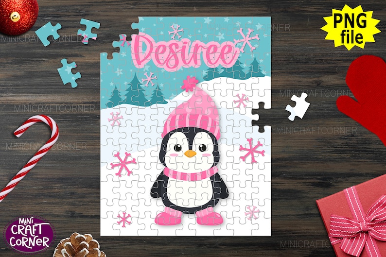 May include: A personalised jigsaw puzzle with a cartoon penguin in a pink hat, scarf, and boots. The name "Desiree" is written in pink script above the penguin. The puzzle is set against a winter scene with snowflakes. Includes a "PNG file" graphic.