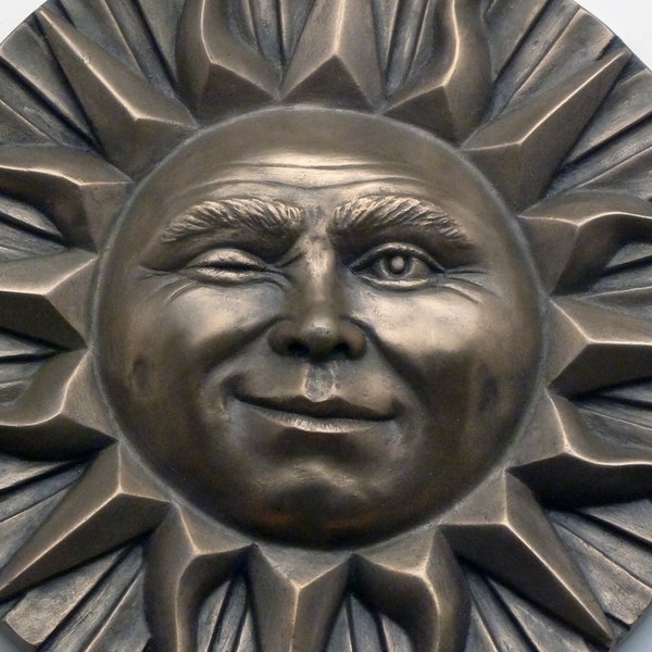 Placa de pared pequeña con cara de sol guiñando el ojo en resina de bronce