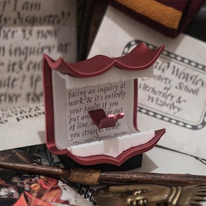 Letra mágica roja chillona impresa en 3D con soporte