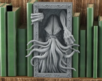 May include: A gray Cthulhu bookend sculpture, framed and set among green books on a wooden shelf. The sculpture features tentacles and a detailed, textured design, adding a unique touch to any bookshelf. The bookend is a decorative item.