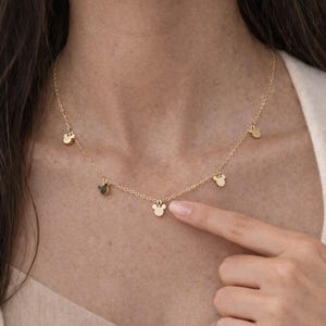 Puede incluir: Un delicado collar dorado con m&uacute;ltiples dijes peque&ntilde;os con forma de cabeza de Mickey Mouse. El collar se lleva alrededor del cuello y es un accesorio sencillo pero encantador. Un gran regalo para los fans de Disney.