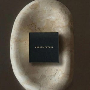 Puede incluir: Un juego de tres tazas de cer&aacute;mica con un esmalte moteado de color crema. Cada taza presenta un dise&ntilde;o floral pintado a mano diferente en tonos azules, verdes y amarillos. Las tazas tienen una forma simple y redondeada.