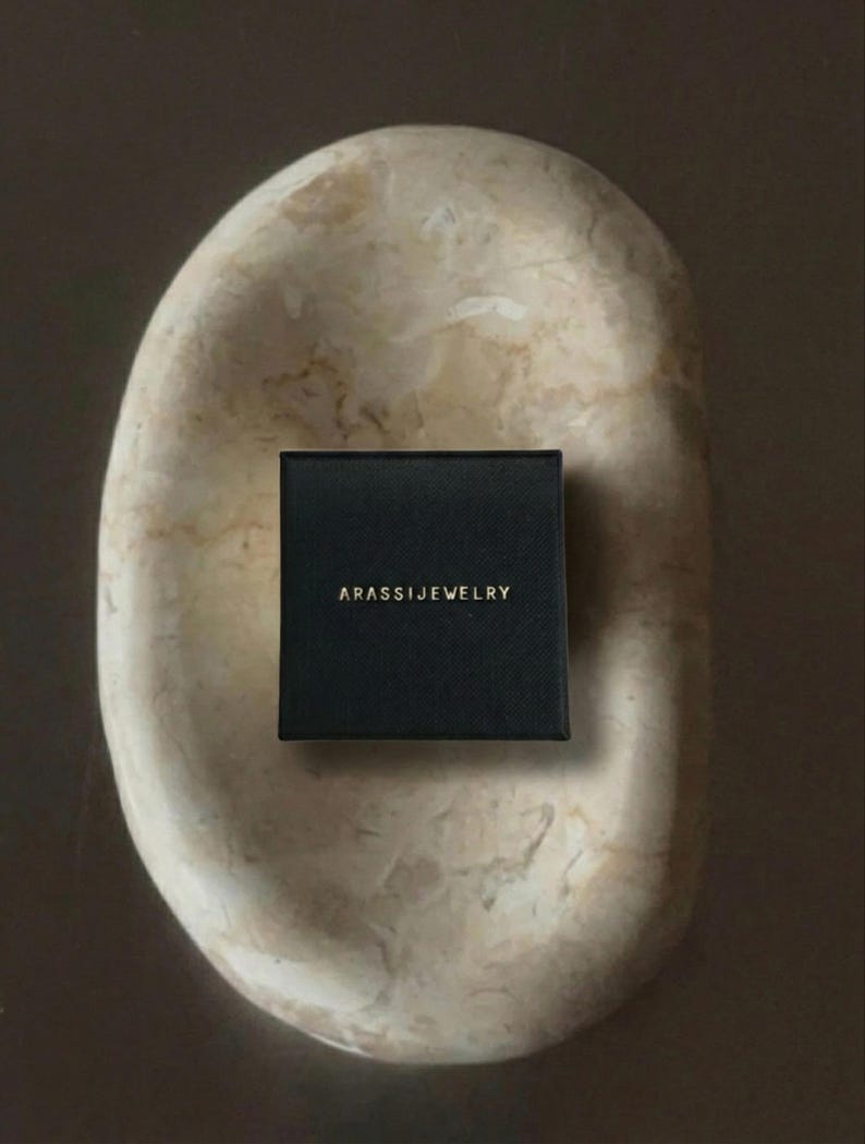 Puede incluir: Un juego de tres tazas de cer&aacute;mica con un esmalte moteado de color crema. Cada taza presenta un dise&ntilde;o floral pintado a mano diferente en tonos azules, verdes y amarillos. Las tazas tienen una forma simple y redondeada.